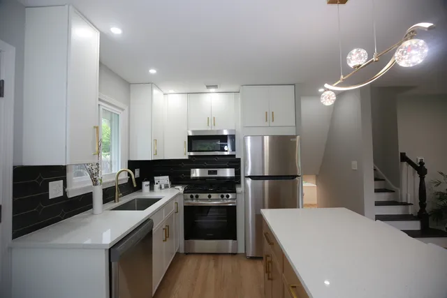 a kitchen with a refrigerator a stove a microwave and cabinets
