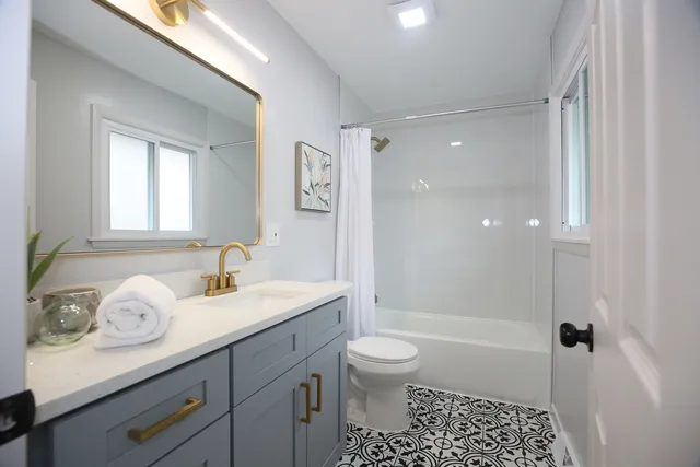 a bathroom with a sink a toilet and shower