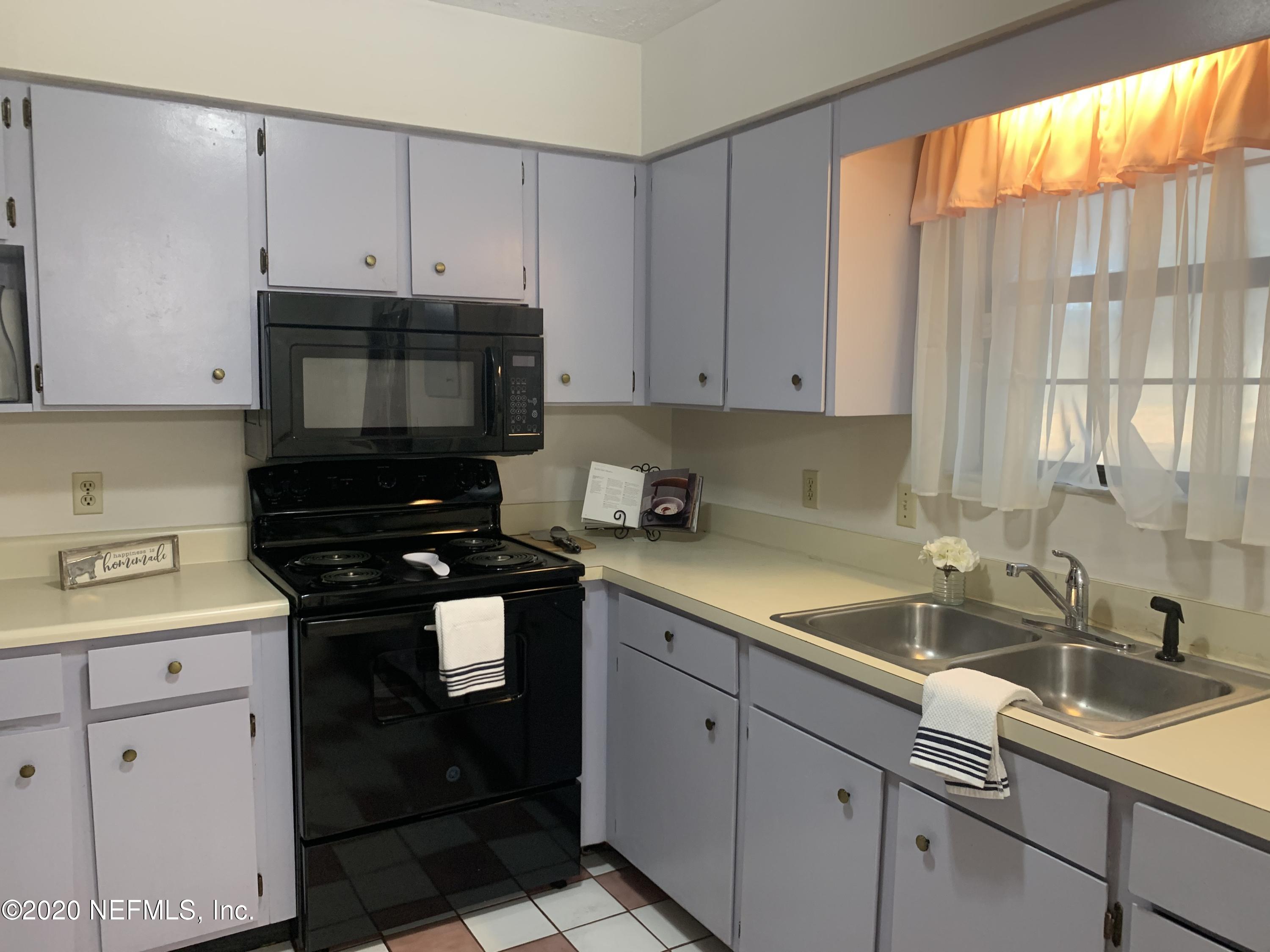 420 Southwest Naha Street Keystone Heights, FL 32656 - Photo 12 of 29 a kitchen with granite countertop a sink stainless steel appliances white cabinets and a window