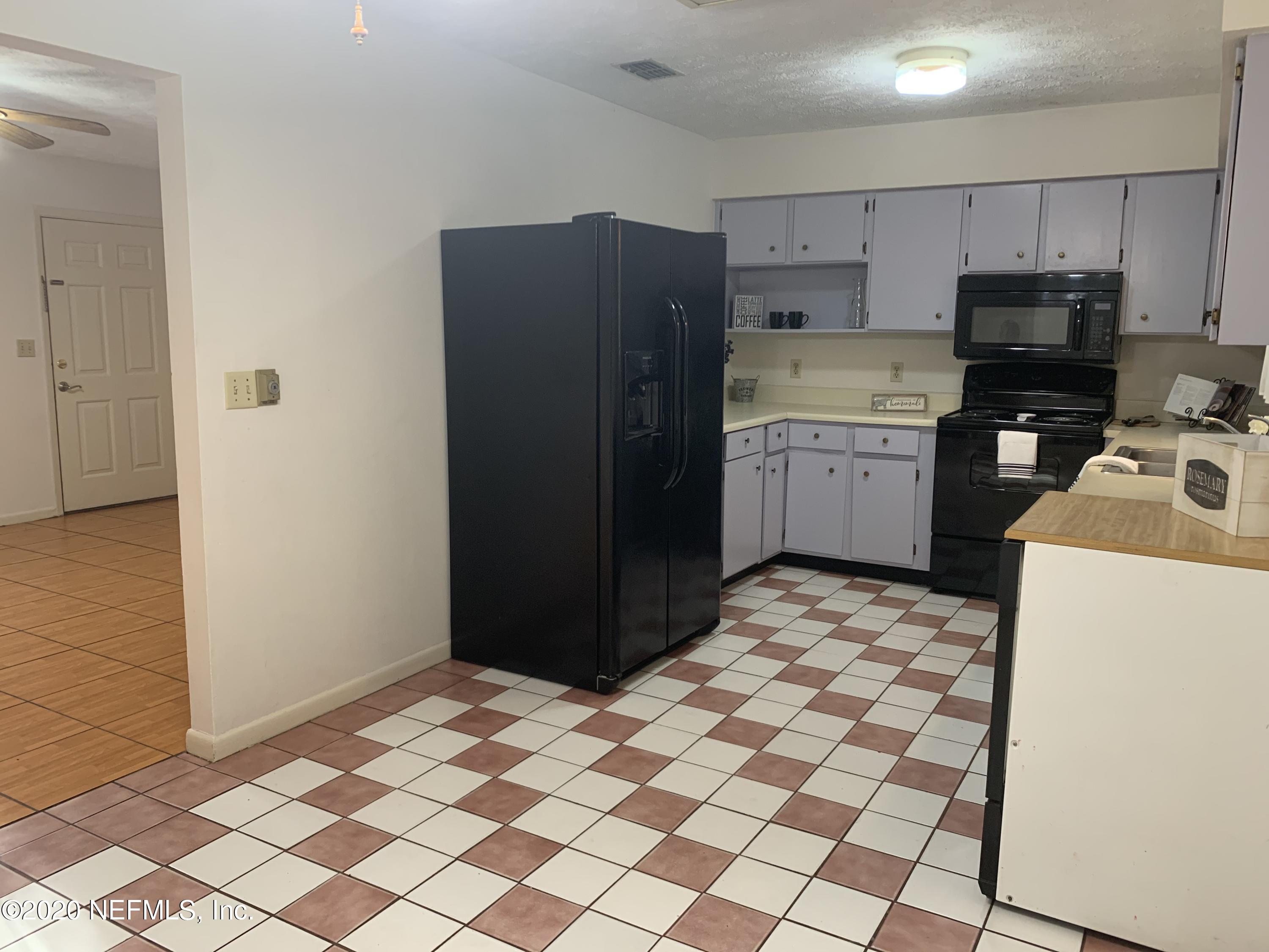 420 Southwest Naha Street Keystone Heights, FL 32656 - Photo 9 of 29 a kitchen with a refrigerator and a stove top oven