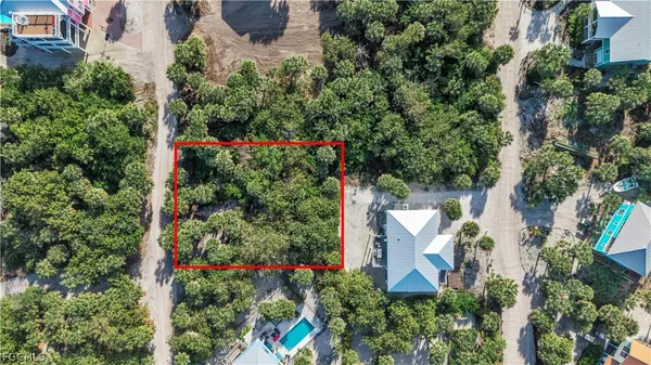 an aerial view of residential house with outdoor space and trees all around