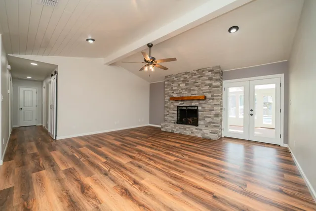 a view of empty room with wooden floor and fireplace