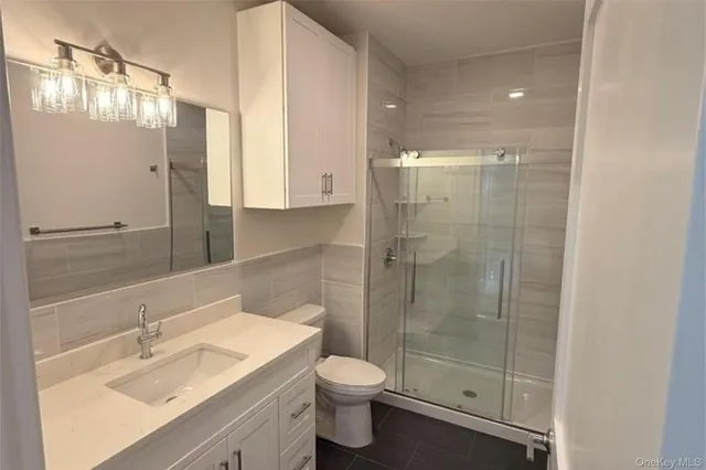 a bathroom with a shower sink vanity and toilet