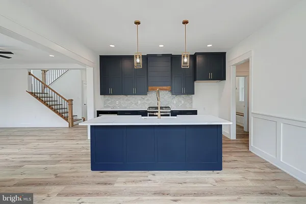 a kitchen with stainless steel appliances granite countertop a sink a stove and a wooden floors