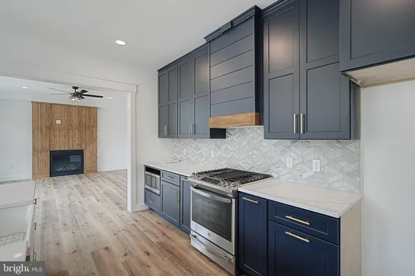 a kitchen with granite countertop a stove and a wooden cabinets