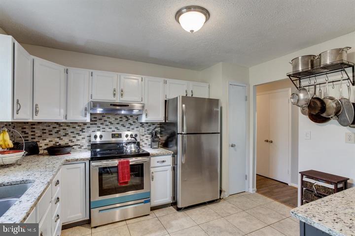 37352 Asher Road Mechanicsville, MD 20659 - Photo 5 of 11 a kitchen with stainless steel appliances granite countertop a stove a refrigerator and a sink