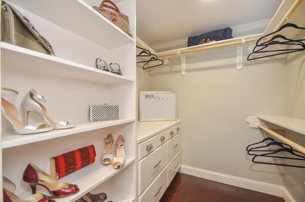 a view of walk in closet with clothes and shoes