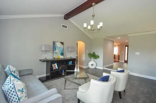 a living room with furniture a chandelier and a mirror