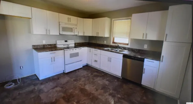 a kitchen with granite countertop cabinets stainless steel appliances and a sink