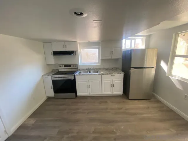 a kitchen with a stove a refrigerator and a sink