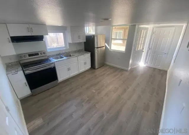 a kitchen with stainless steel appliances granite countertop a stove a sink and a refrigerator