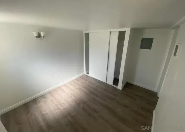 an empty room with wooden floor and a window