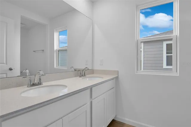a bathroom with a sink and two mirror