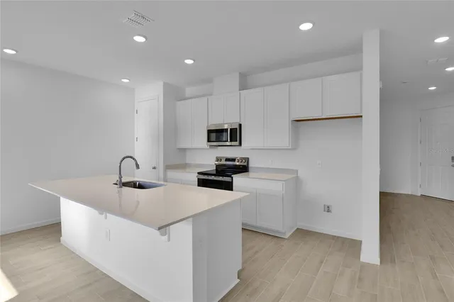 a kitchen with sink a microwave and refrigerator
