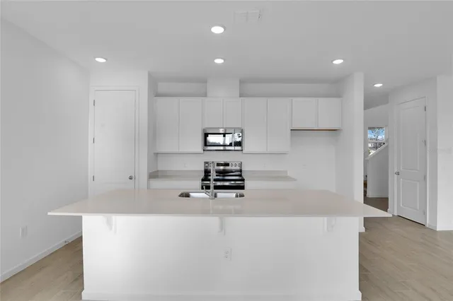 a kitchen with kitchen island a stove and a refrigerator