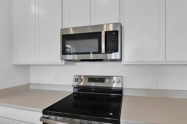 a kitchen with stainless steel appliances granite countertop a stove a microwave and cabinets