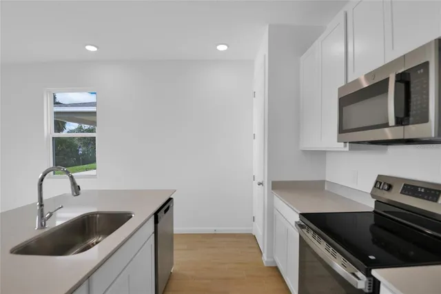 a kitchen with stainless steel appliances granite countertop a sink and a microwave