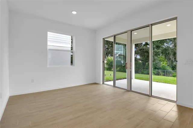 a view of an empty room with wooden floor and a floor to ceiling window