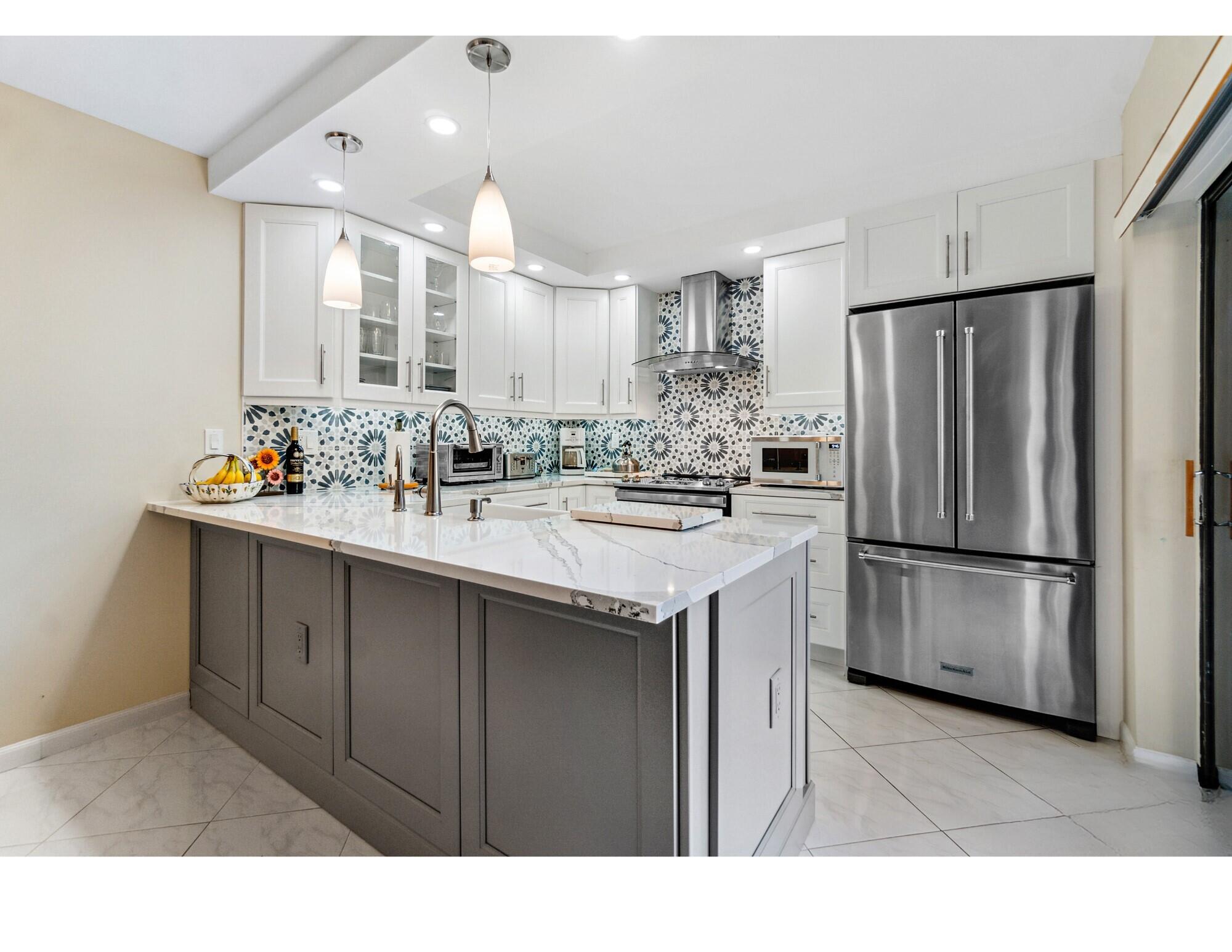 2906 29th Court Jupiter, FL 33477 - Photo 11 of 31 a kitchen with a sink refrigerator and cabinets