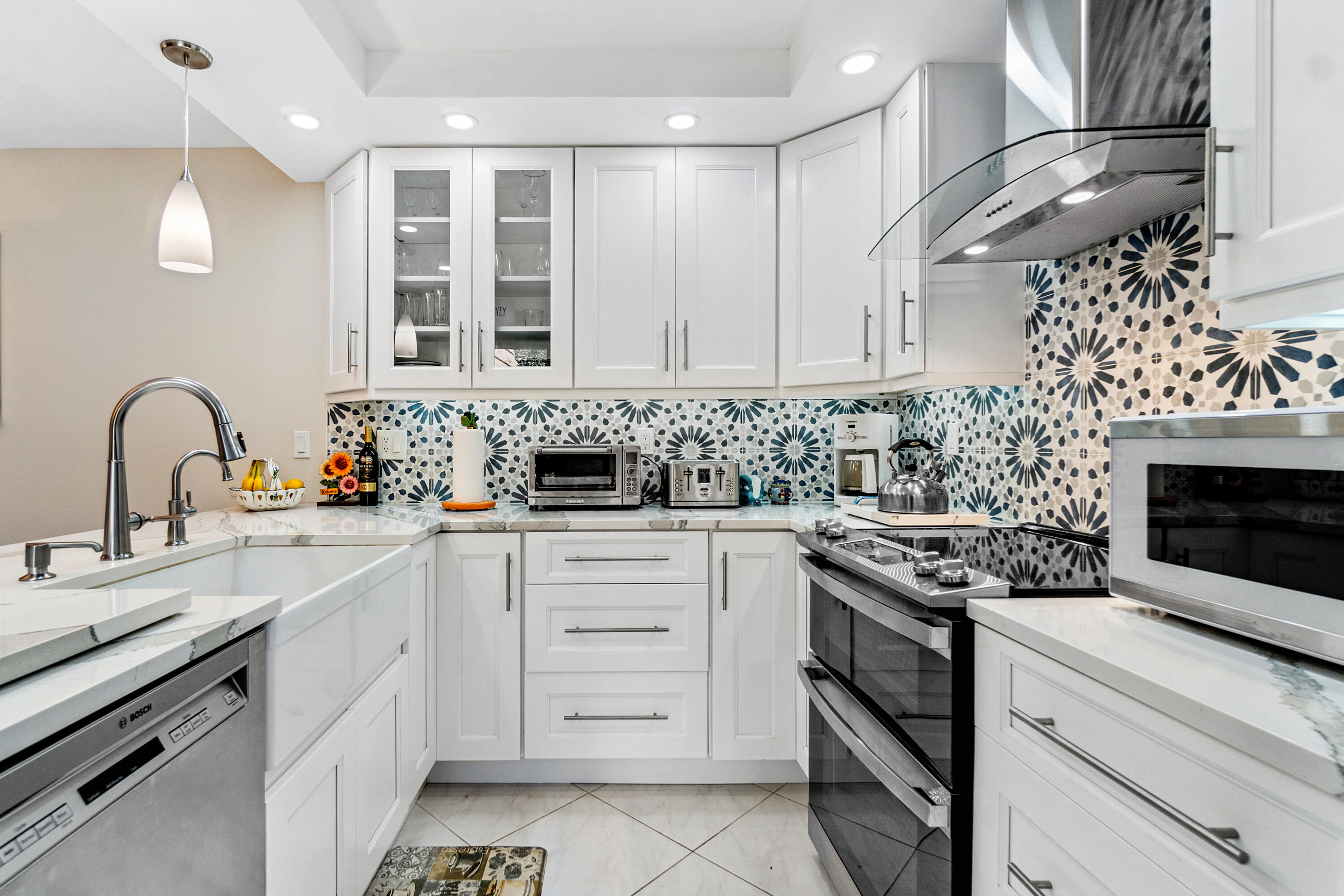 2906 29th Court Jupiter, FL 33477 - Photo 12 of 31 a kitchen with white cabinets and appliances