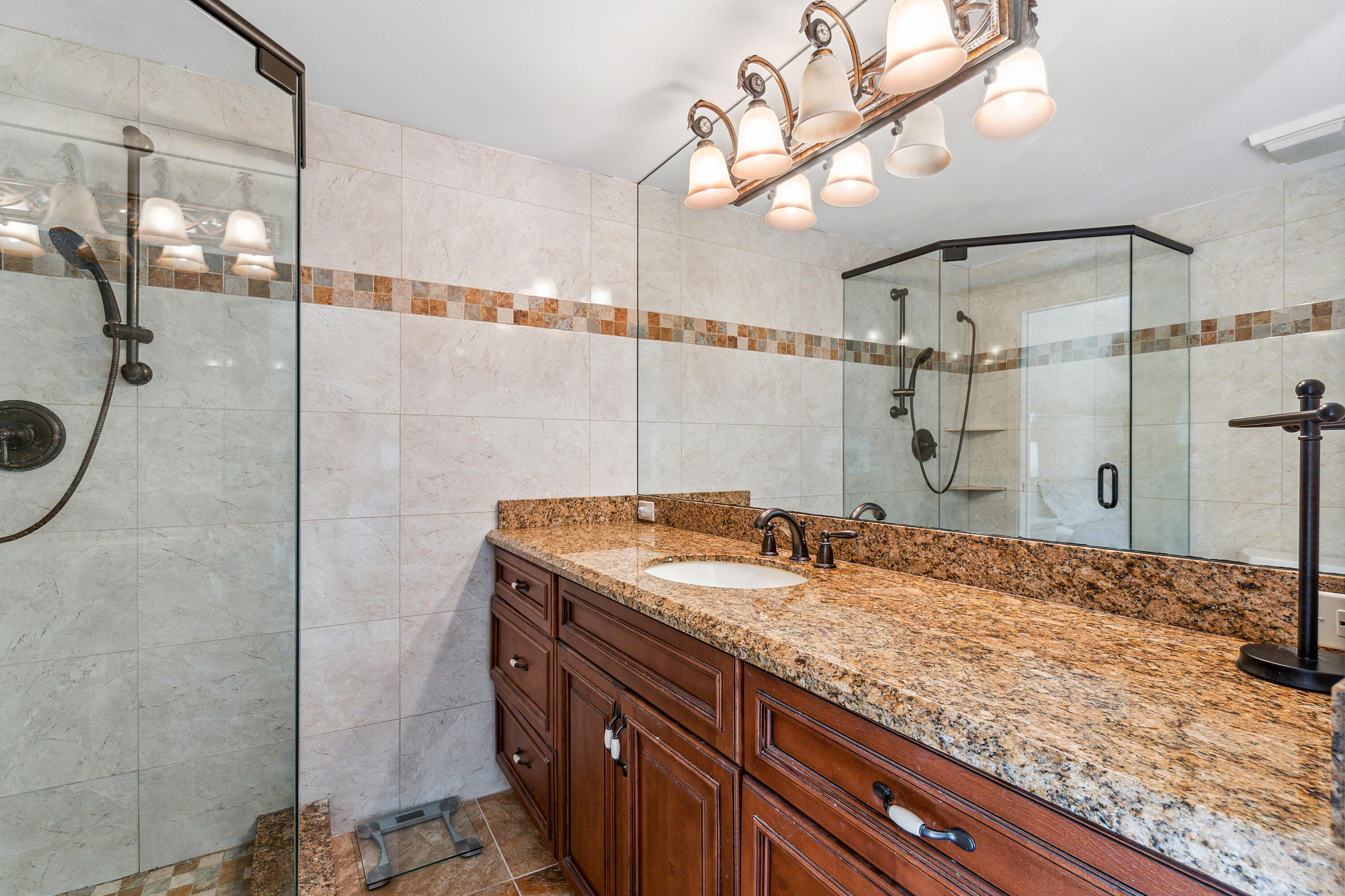 2906 29th Court Jupiter, FL 33477 - Photo 21 of 31 a bathroom with a granite countertop sink a mirror and shower