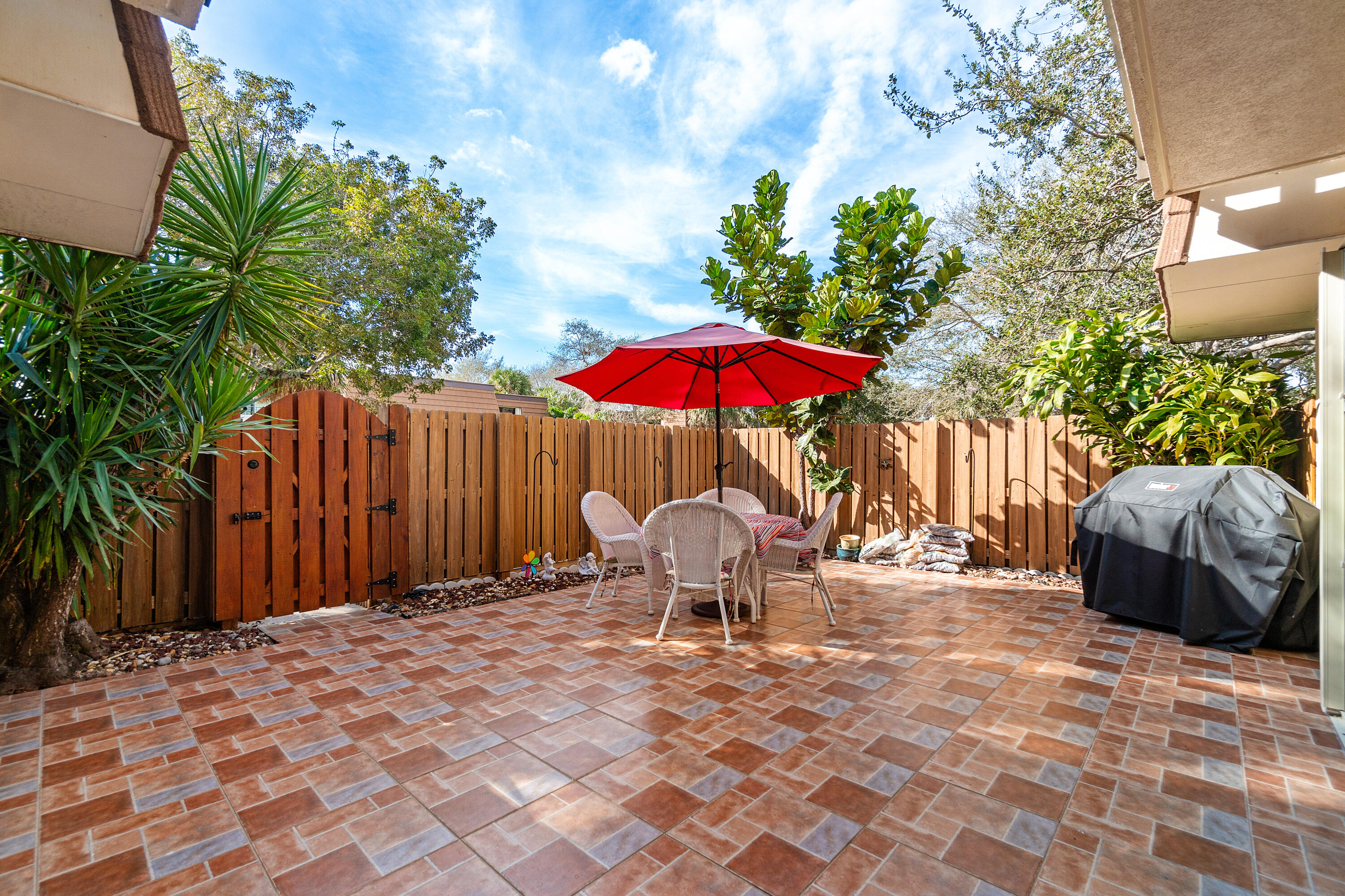 2906 29th Court Jupiter, FL 33477 - Photo 4 of 31 a backyard of a house with table and chairs