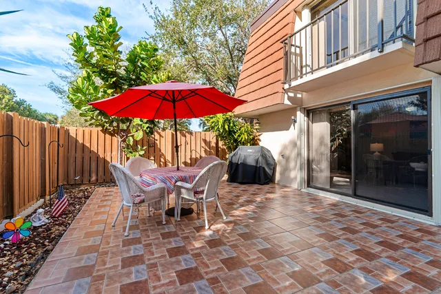 a view of a patio with table and chairs under an umbrella