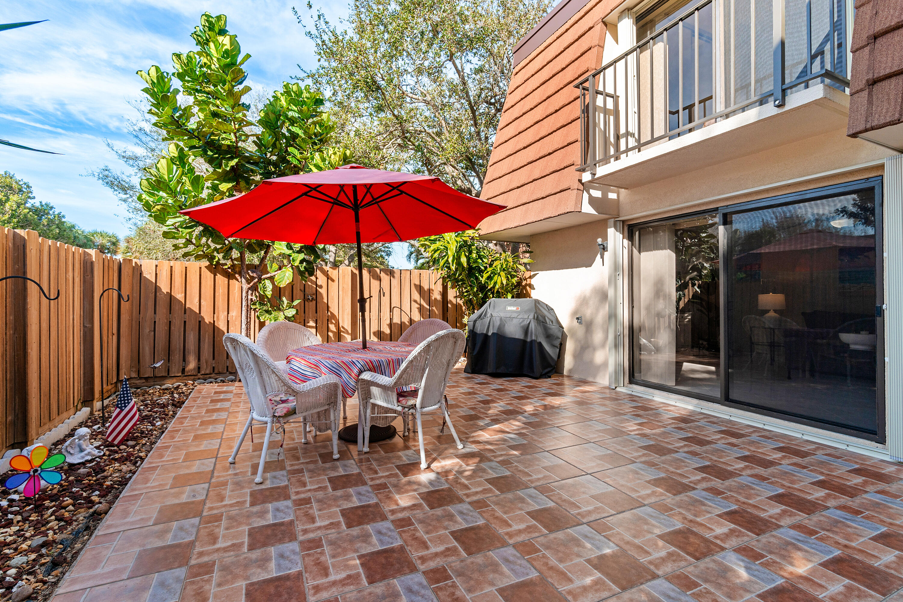 2906 29th Court Jupiter, FL 33477 - Photo 5 of 31 a view of a patio with table and chairs under an umbrella