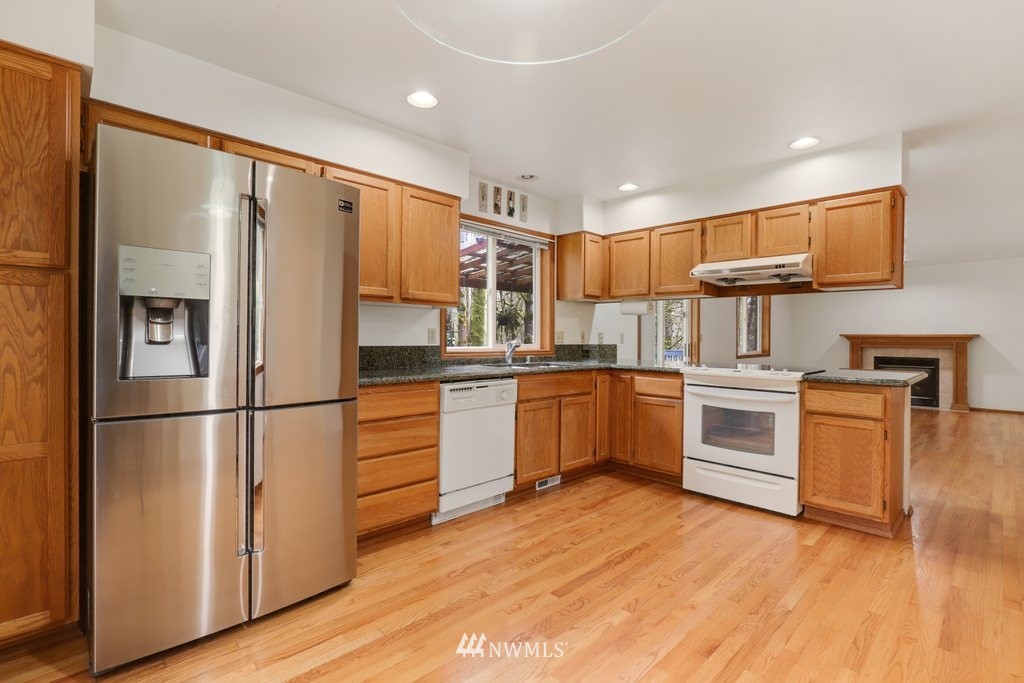 9641 South 194th Street Renton, WA 98055 - Photo 8 of 29 a kitchen with white cabinets and stainless steel appliances