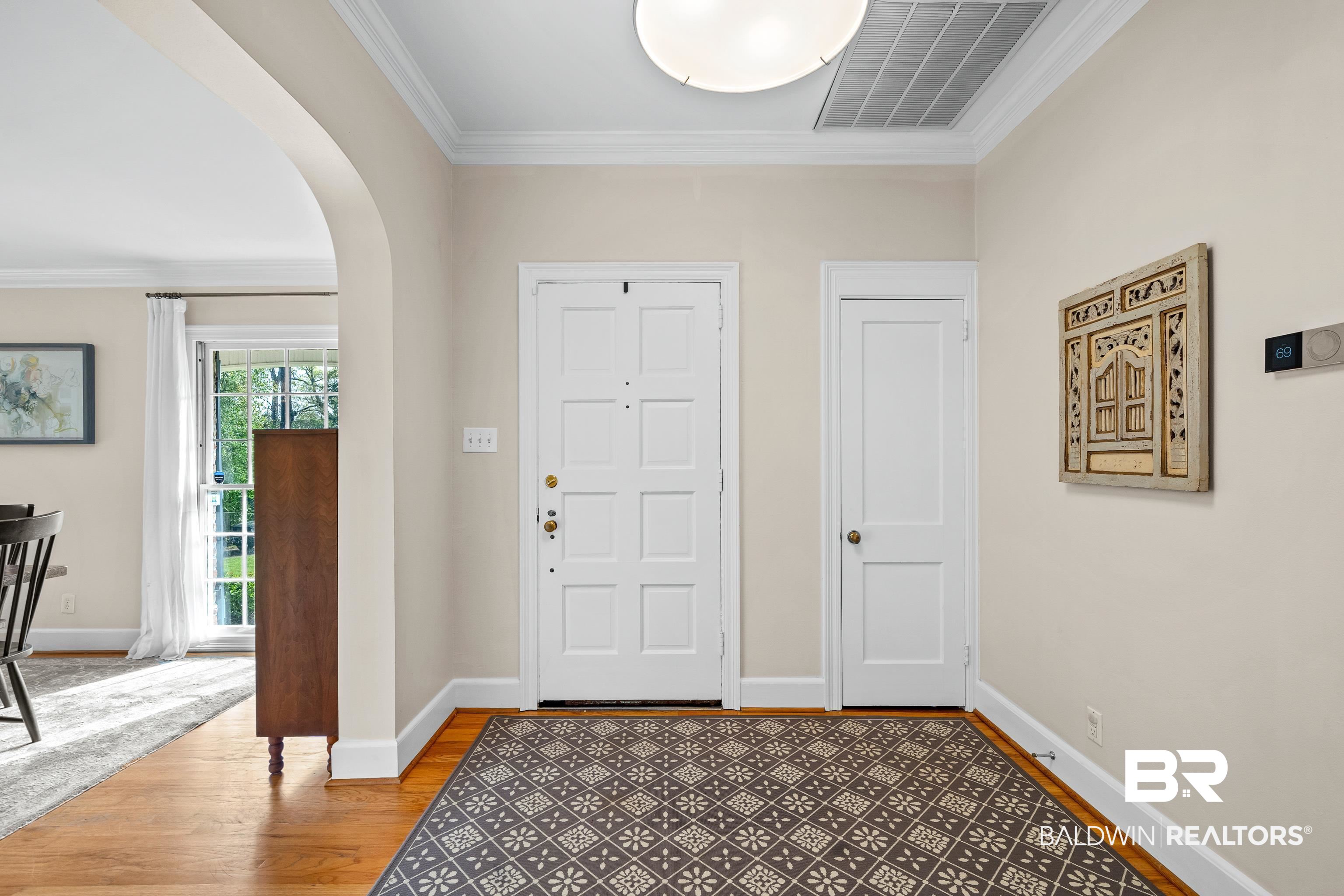141 Myrtlewood Lane Mobile, AL 36608 - Photo 3 of 44 Entryway featuring crown molding, light wood-style floors, baseboards, visible vents, and arched walkways