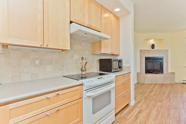 a kitchen with granite countertop a stove sink and cabinets