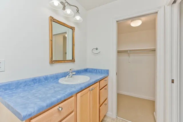 a bathroom with a granite countertop sink and a mirror