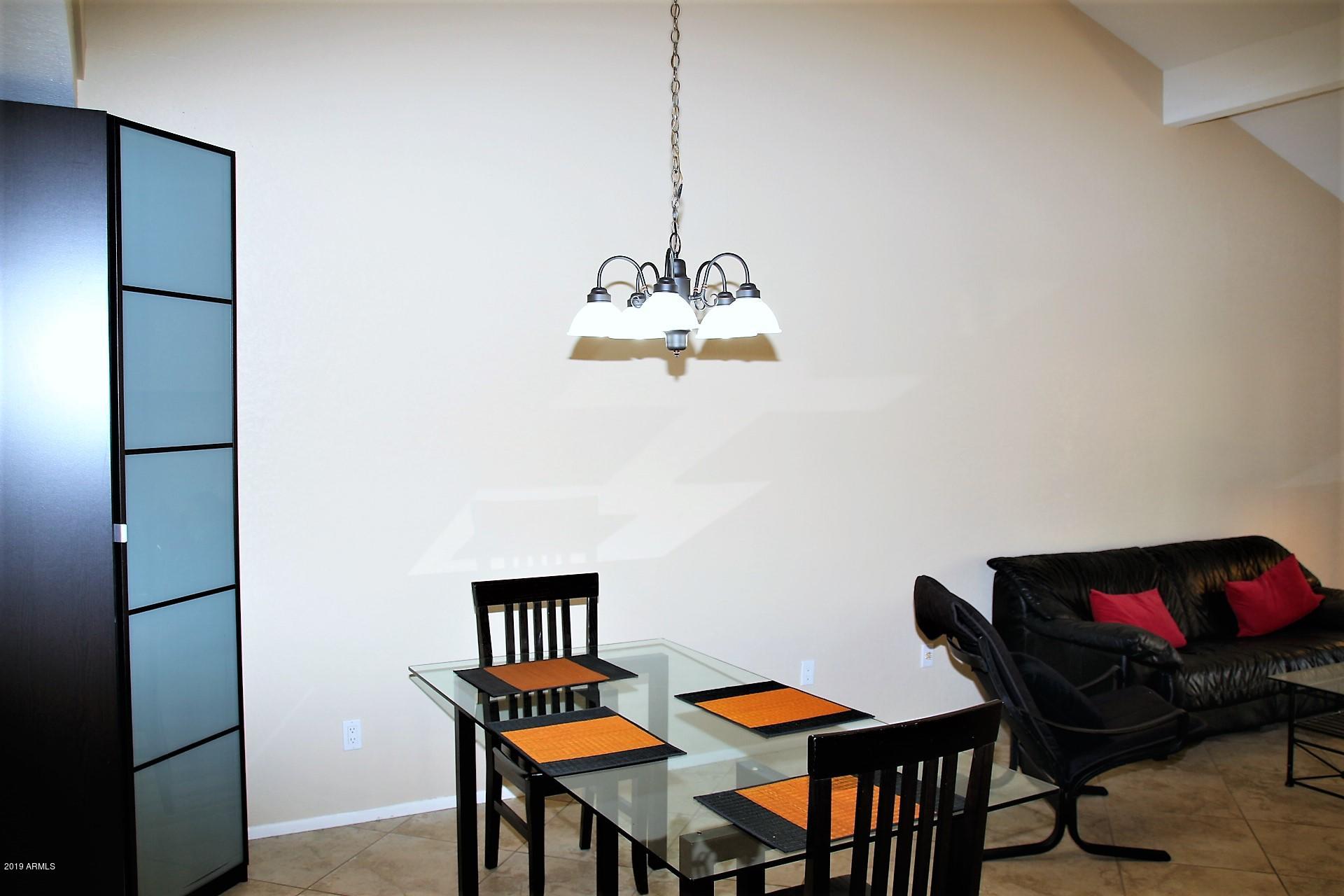 11615 North 40th Way Phoenix, AZ 85028 - Photo 15 of 33 a view of a dining room with furniture and wooden floor