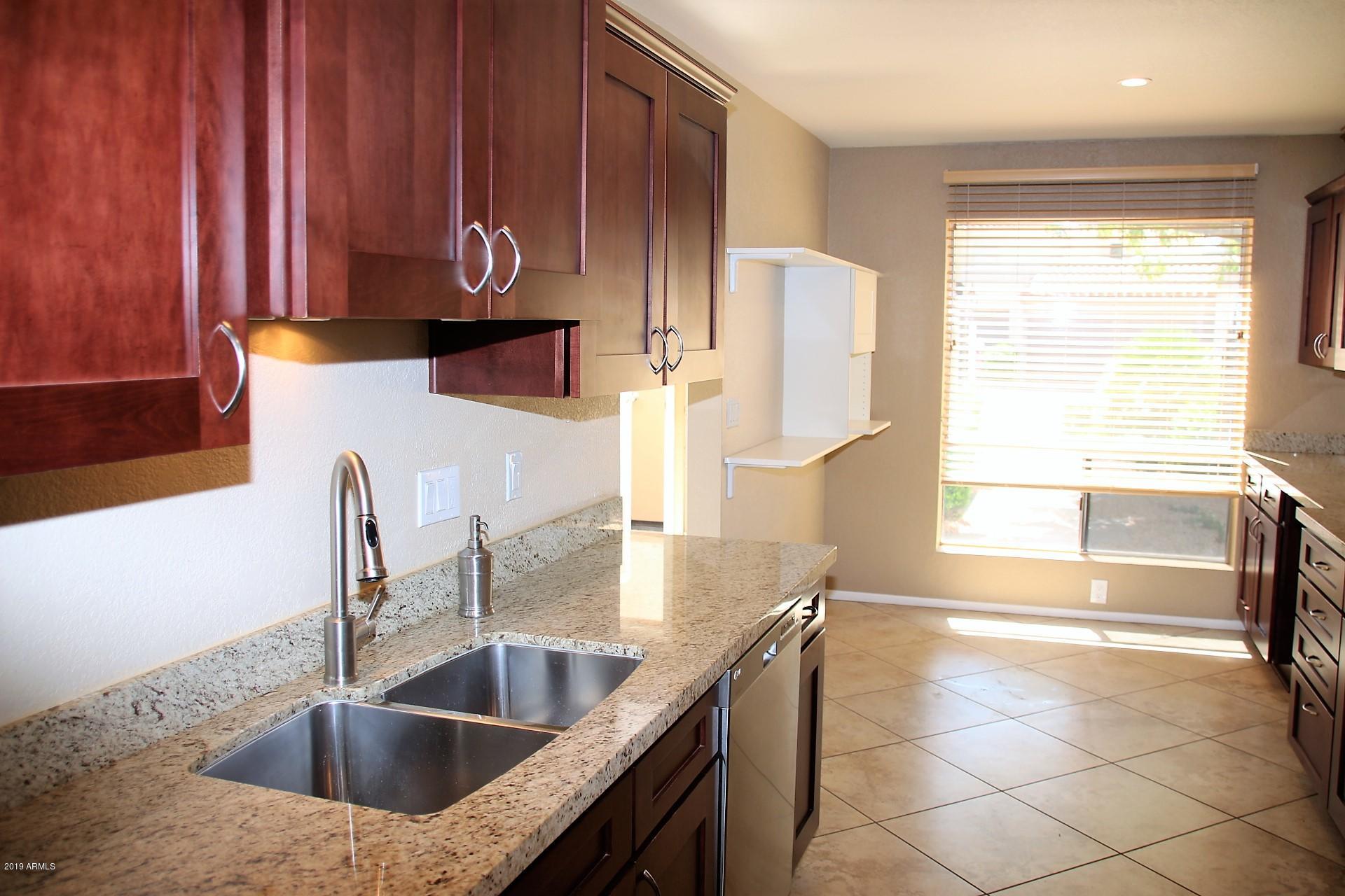 11615 North 40th Way Phoenix, AZ 85028 - Photo 24 of 33 a kitchen with stainless steel appliances granite countertop a sink and a wooden cabinets
