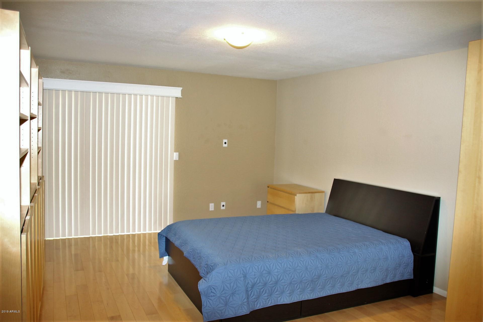 11615 North 40th Way Phoenix, AZ 85028 - Photo 27 of 33 a bedroom with a bed and lamp