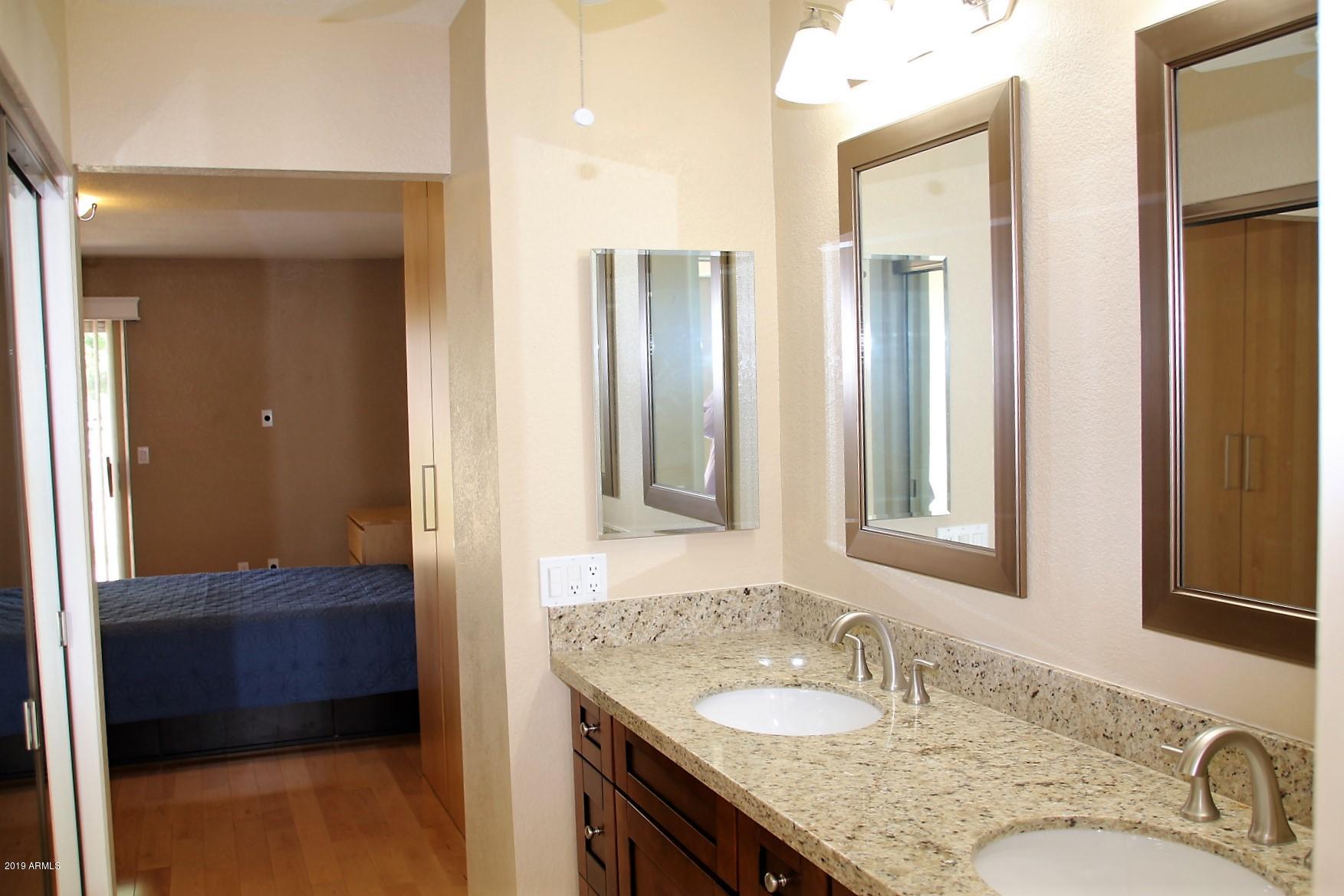 11615 North 40th Way Phoenix, AZ 85028 - Photo 30 of 33 a en suite bathroom with a granite countertop sink and a mirror