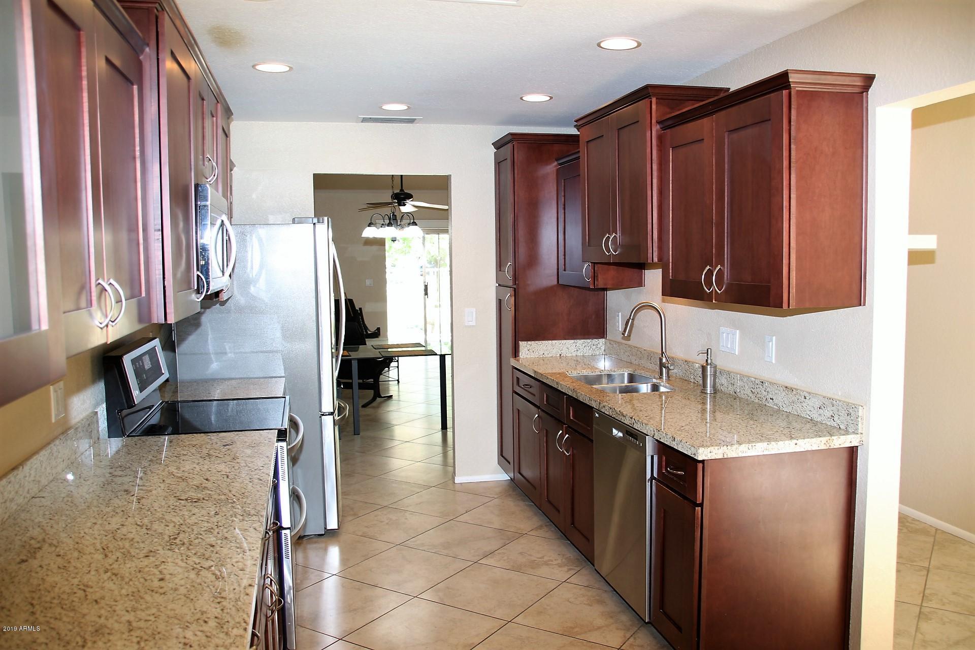 11615 North 40th Way Phoenix, AZ 85028 - Photo 4 of 33 a kitchen with stainless steel appliances granite countertop a sink and a refrigerator