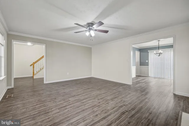 a view of an empty room with wooden floor fireplace and a window