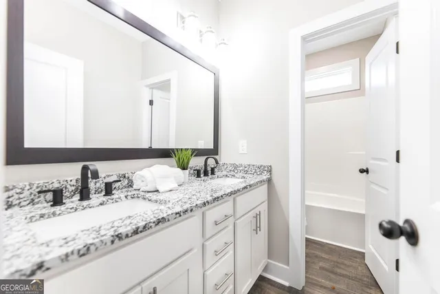 a bathroom with a granite countertop sink and a mirror