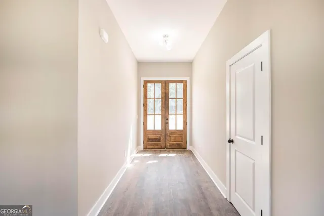 a view of a hallway with wooden floor and closet