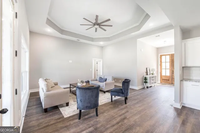 a living room with furniture and a wooden floor