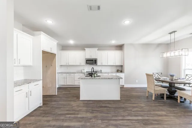 a kitchen with white cabinets and white appliances