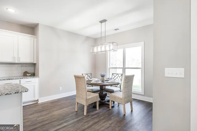 a dining room with furniture a chandelier and wooden floor
