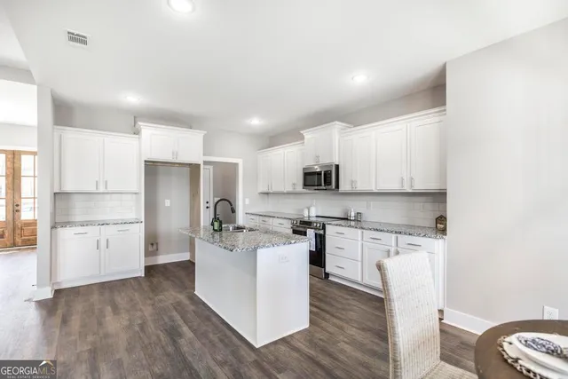 a kitchen with white cabinets and stainless steel appliances