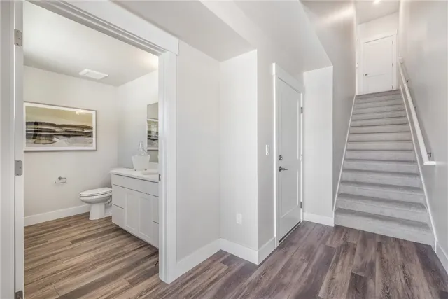 a view of a bathroom with wooden floor and a ceiling fan