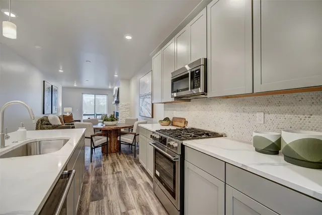 a kitchen with stainless steel appliances granite countertop a sink stove and microwave