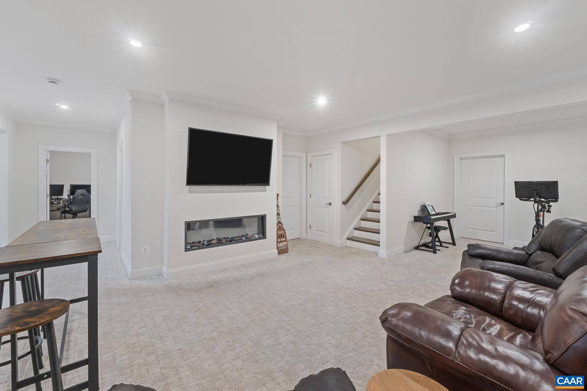 3712 Thicket Run Place Charlottesville, VA 22911 - Photo 45 of 73 a living room with furniture a fireplace and a flat screen tv