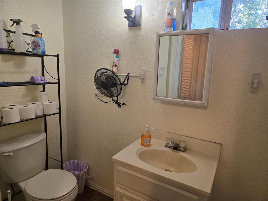 535 Hancock Street Gainesville, TX 76240 - Photo 17 of 22 a bathroom with a toilet sink and mirror