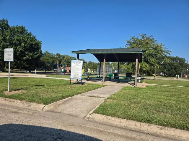 a view of a park with swings on and brick wall