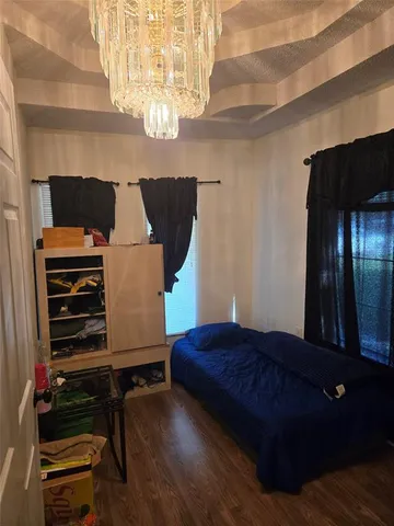 a bedroom with a bed and a chandelier